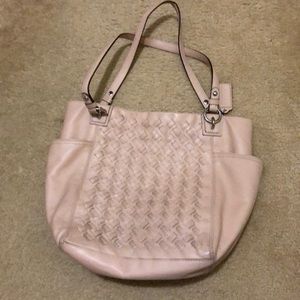 Beige coach purse with a pinkish hugh